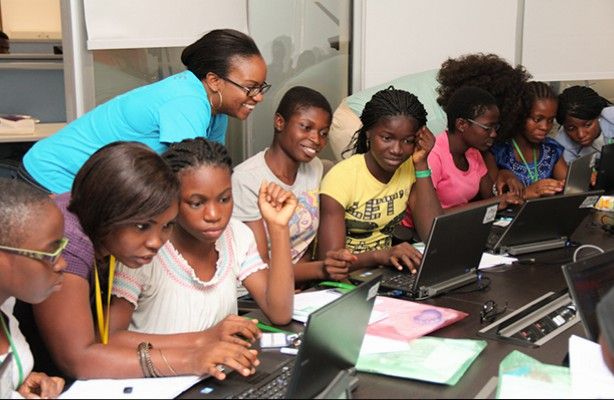 Formatrice accompagnant des jeunes pendant une séance de sensibilisation sur ordinateurs portables
